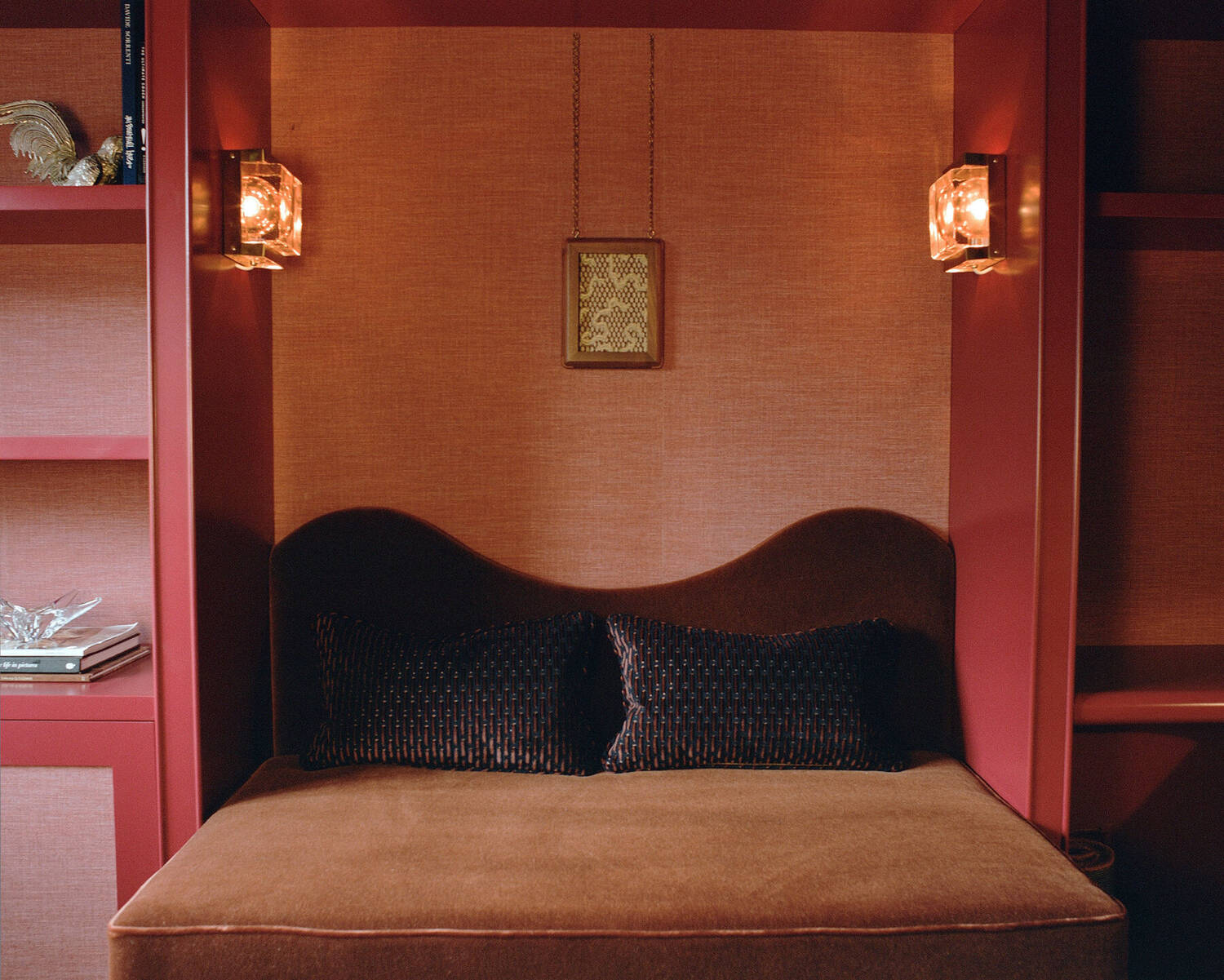Velvet daybed set within a red panelled niche