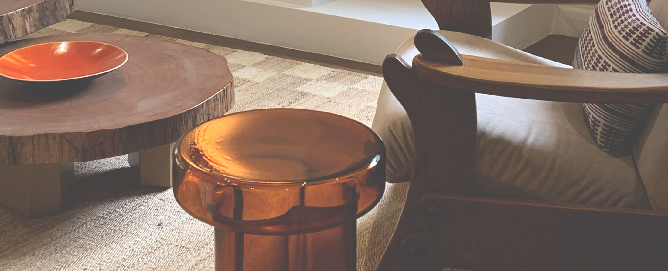 Carved timber coffee tables with lacquered bowl and woven rug