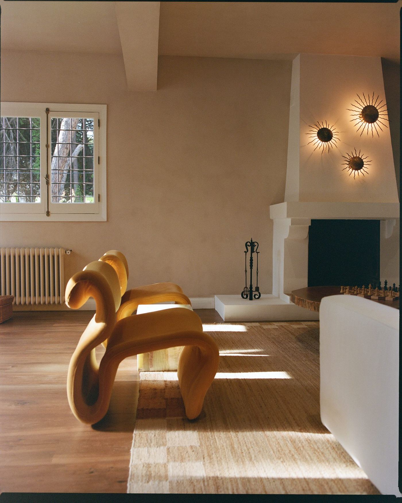 Living room with a sculptural wood bench and fireplace nook
