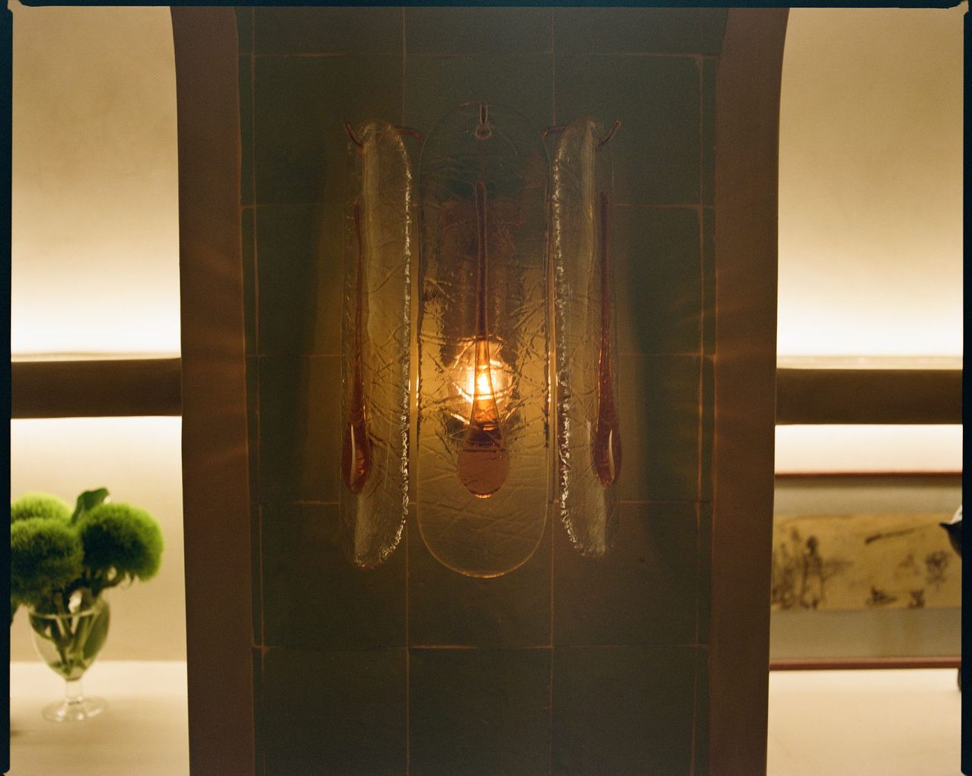Etched glass screen with a glowing wall sconce