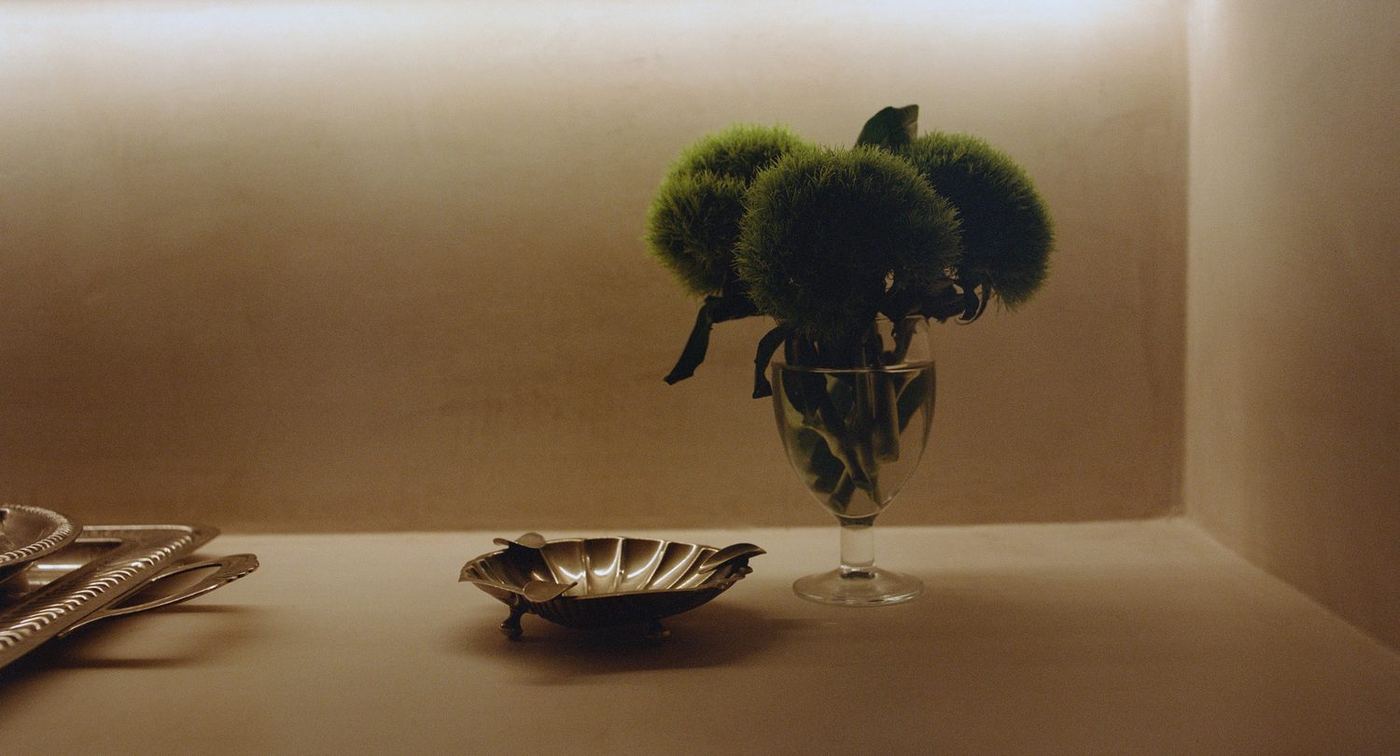 Green glass vase and bowls arranged on a console